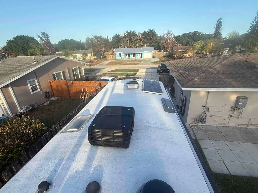 Triton RV technician replacing a rooftop AC unit on an RV at a Florida campground