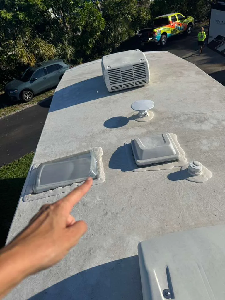 Triton RV technician repairing a rubber roof leak on an RV in Florida